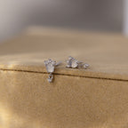 Halo Moonstone Drop Studs in Sterling Silver showcase royal elegance with their teardrop-shaped stones, beautifully displayed on a light tan velvet surface.