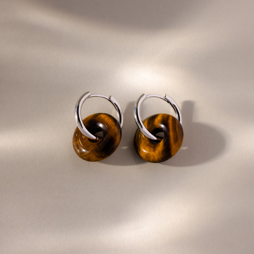 Tiger's Eye Duo Hoops: Silver hoop earrings feature brown circular accents, reminiscent of Tiger’s Eye, displayed on a neutral, softly lit background.