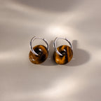 Tiger's Eye Duo Hoops: Silver hoop earrings feature brown circular accents, reminiscent of Tiger’s Eye, displayed on a neutral, softly lit background.