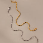 The Oval Beaded Bracelet in Silver features polished beads and a secure clasp, offering a chic touch of modern jewelry to any outfit.
