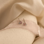 The Pink Baguette Opal Studs in Silver rest on soft pale pink fabric—perfect for bridal gifts or thoughtful bridesmaid presents.