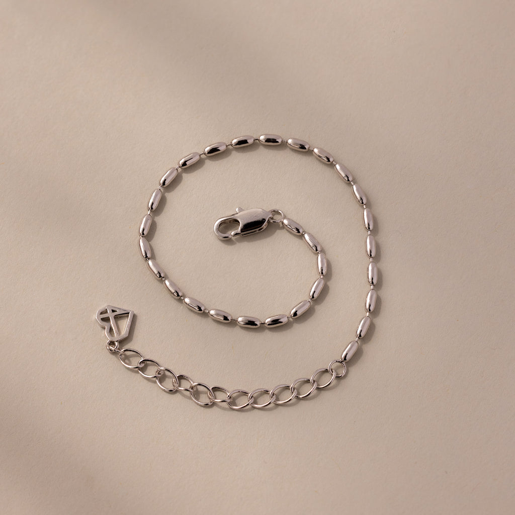 The Oval Beaded Bracelet in Silver features an elegant oval link design and a secure lobster clasp, perfect for adding a modern touch to any look.