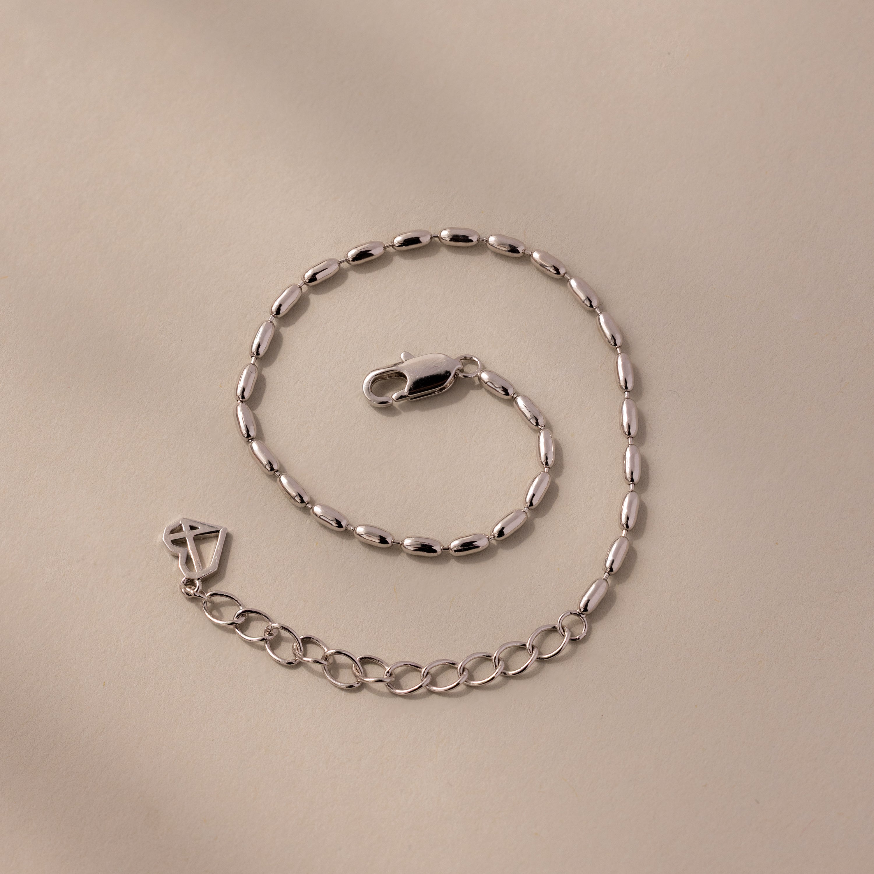 The Oval Beaded Bracelet in Silver features an elegant oval link design and a secure lobster clasp, perfect for adding a modern touch to any look.
