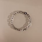The Eternal Link Bracelet in Silver features rectangular links in a circle on a beige background, highlighting its geometric, modern design.