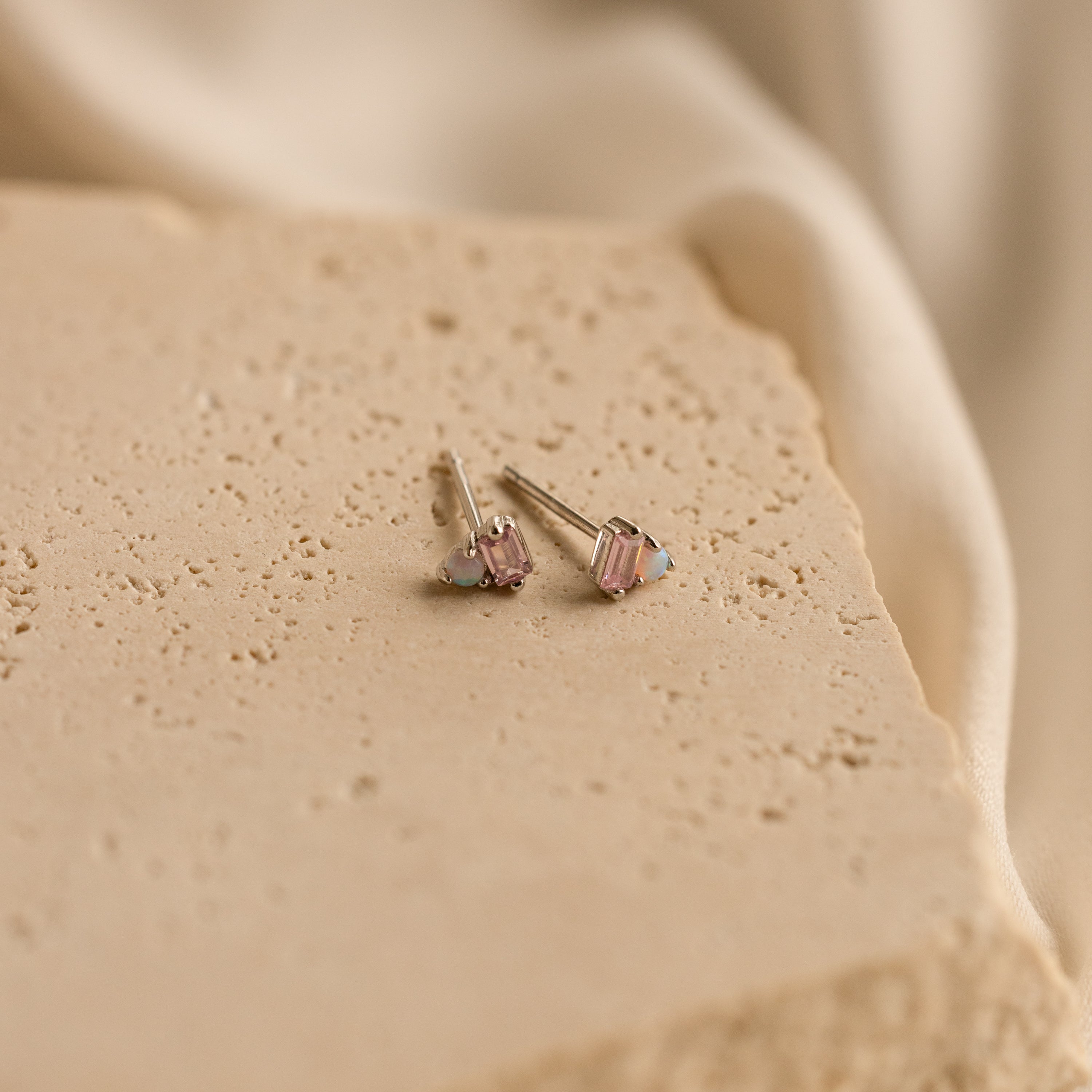 Pink Baguette Opal Studs in Silver with rectangular gemstones on a textured beige stone surface—perfect as bridesmaid or bridal gifts.