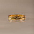 The Peridot Inlay Eternity Ring features a geometric engraved gold band with a subtle peridot inlay, shown on a reflective surface against a neutral background.