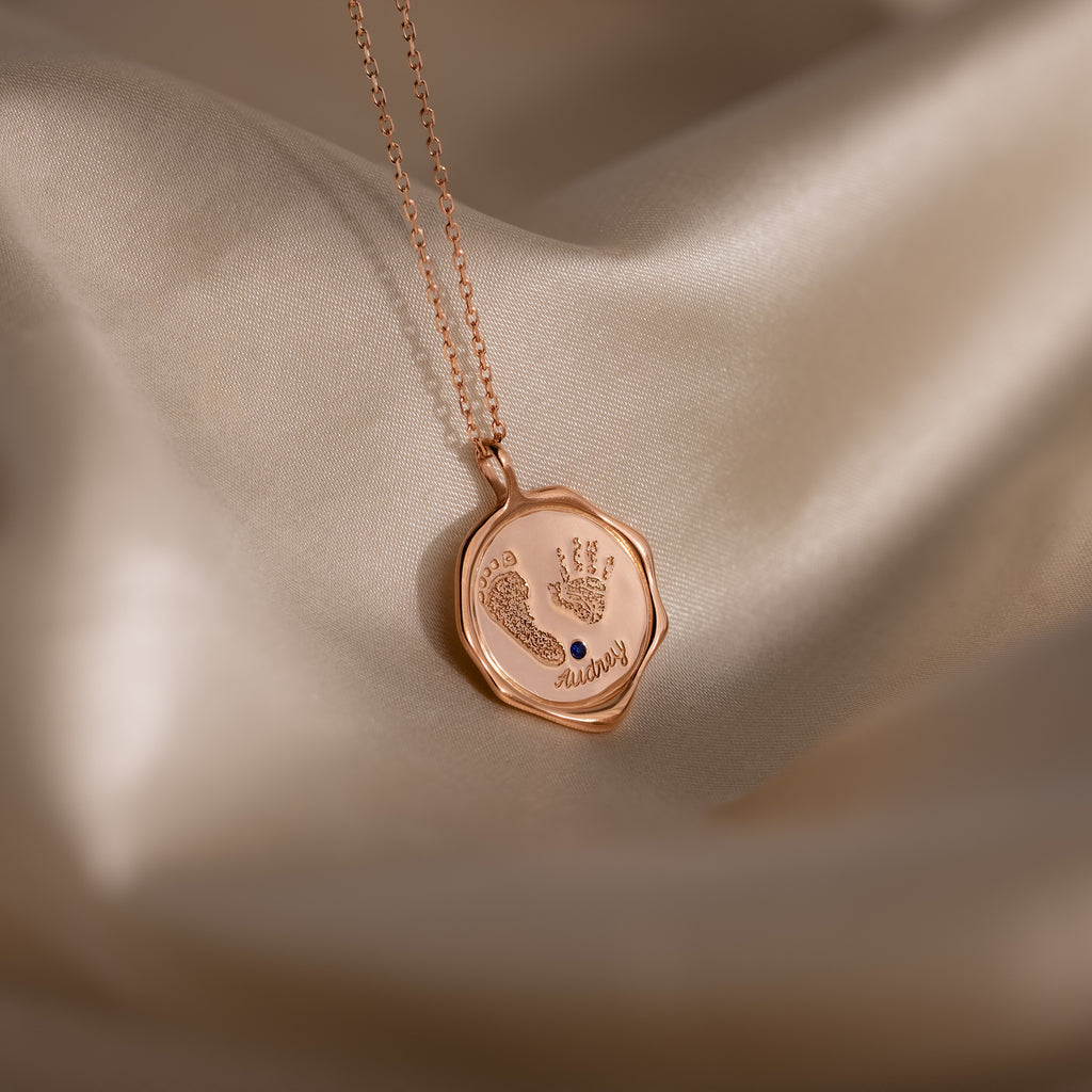 The Baby Hand & Footprint Necklace in Rose Gold features tiny engraved handprints, footprints, and the word "always"—a personalized keepsake necklace for parents to treasure.