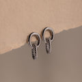 Twisted Link Earrings in White Gold featuring textured chain links are showcased on a torn beige paper background—a perfect blend of modern design and classic jewelry style.