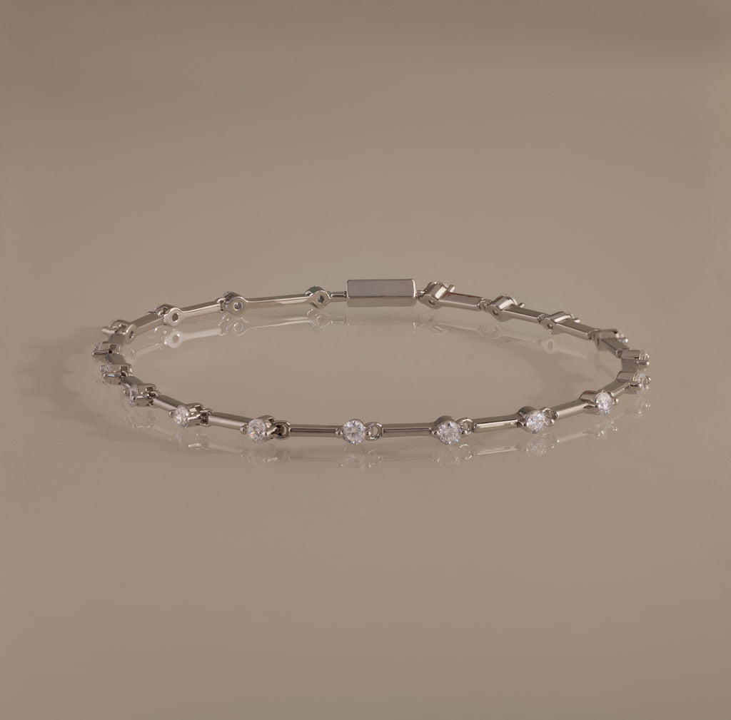 The Sprinkle Diamond Tennis Bracelet in Silver features evenly spaced round diamonds and is displayed on a neutral background.