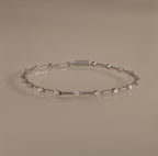 The Sprinkle Diamond Tennis Bracelet in Silver features evenly spaced round diamonds and is displayed on a neutral background.