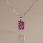 Ruby Birth Flower Charm Necklace with a rectangular pendant showcases a flower design on a pink background, mirrored below.