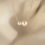 The Dainty Duo Pearl Necklace in Silver features two pearls—a small and a large—on a delicate chain, making it a perfect wedding accessory or thoughtful gift for loved ones.