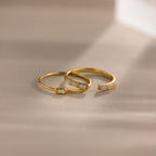 Minimalist gold ring set with baguette-cut opals — one with a single opal and the other with five opals in a row, shown in soft natural light.