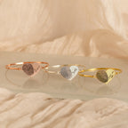 Three Fingerprint Heart Bangles, each engraved with a unique fingerprint and name—Grandma, Dad, and Mom—create beautifully personalized jewelry.