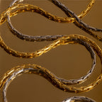The Bold Link Chain Necklace is displayed on a reflective brown surface, highlighting its striking modern chain style.
