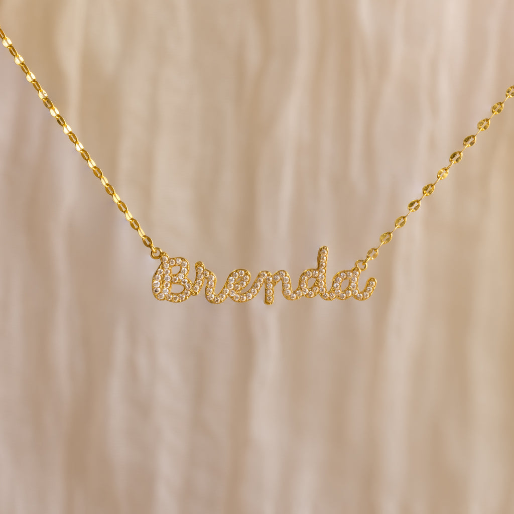 The Pave Dream Script Name Necklace features "Brenda" in elegant cursive, adorned with sparkling pavé crystals for a dazzling touch.