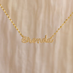 The Pave Dream Script Name Necklace features "Brenda" in elegant cursive, adorned with sparkling pavé crystals for a dazzling touch.