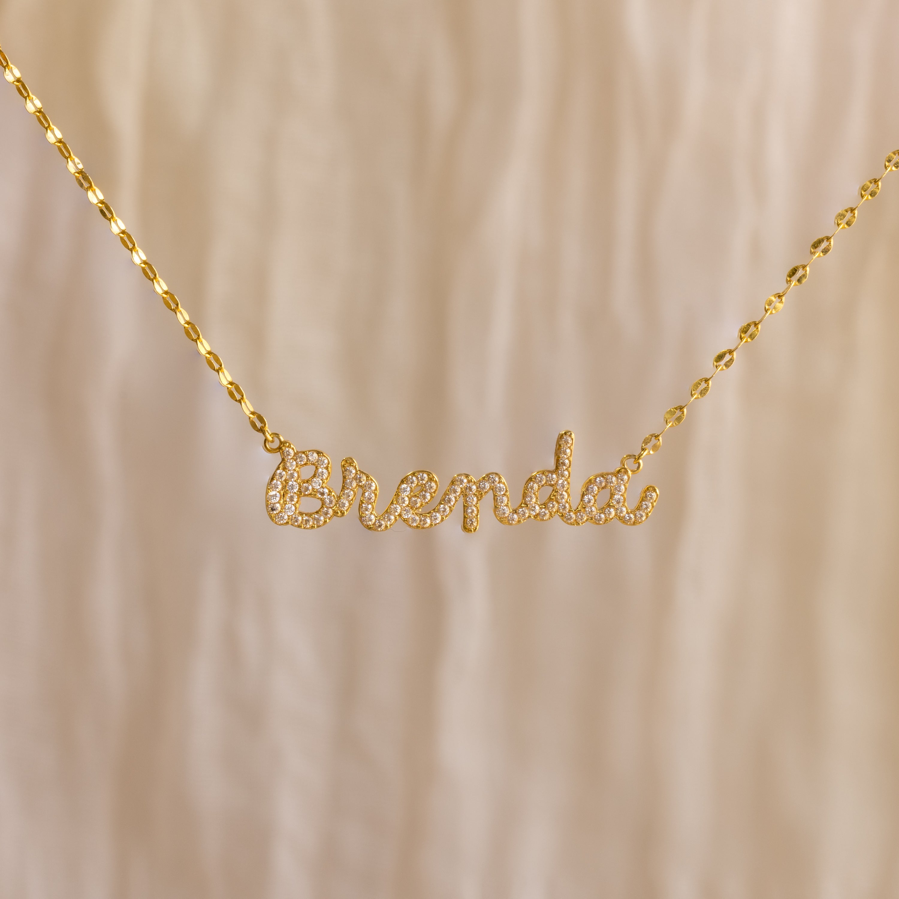 The Pave Dream Script Name Necklace features "Brenda" in elegant cursive, adorned with sparkling pavé crystals for a dazzling touch.