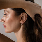 A woman with brown hair holds her hair up to display the Beaded Chunky Hoops in Sterling Silver worn in her left ear.