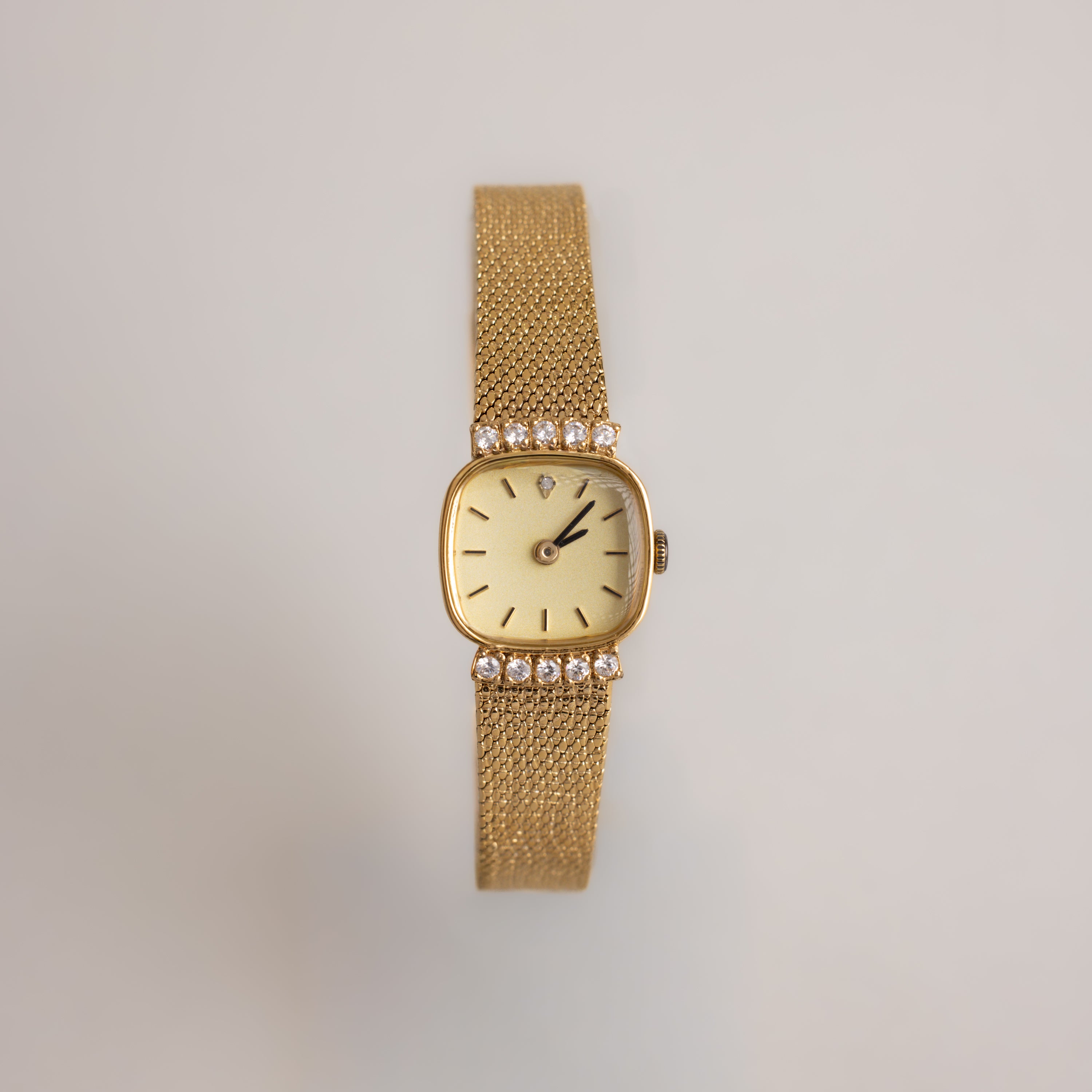 Our Luxe Square Timepiece in 18K Gold watch on a light gray background