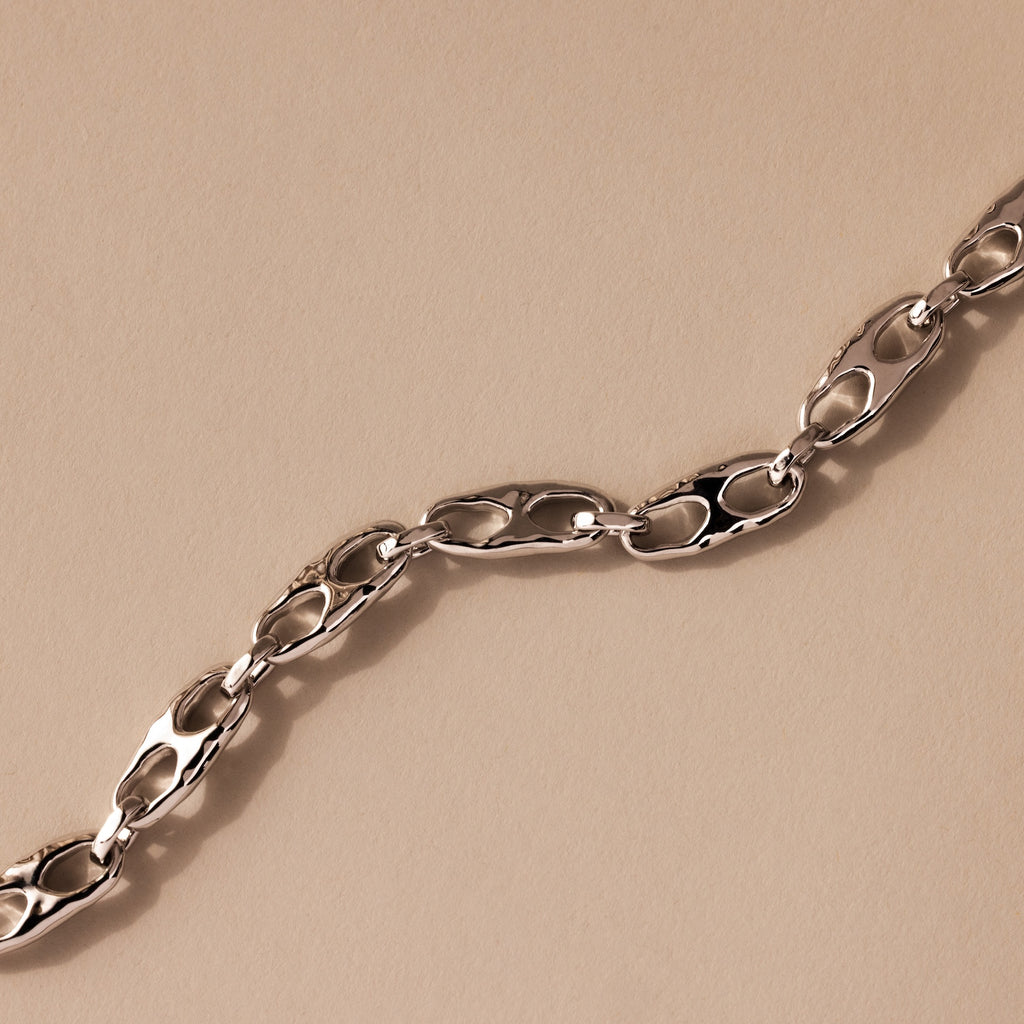 The Organic Mariner Chain Bracelet in Silver features sculptural oval links arranged diagonally, creating a timeless look perfect for any jewelry collection.