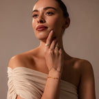 Woman in an off-shoulder beige top styled with gold rings, a turquoise bracelet, and the Ocean Beaded Hand Chain Bracelet in 18K Gold for a chic, layered look.