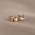 The Pearl Diamond Cluster Studs in 18K Gold feature pearls and two clear gemstones on each stud, set against a neutral backdrop—an elegant accessory for any day.