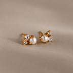 The Pearl Diamond Cluster Studs in 18K Gold feature pearls and two clear gemstones on each stud, set against a neutral backdrop—an elegant accessory for any day.