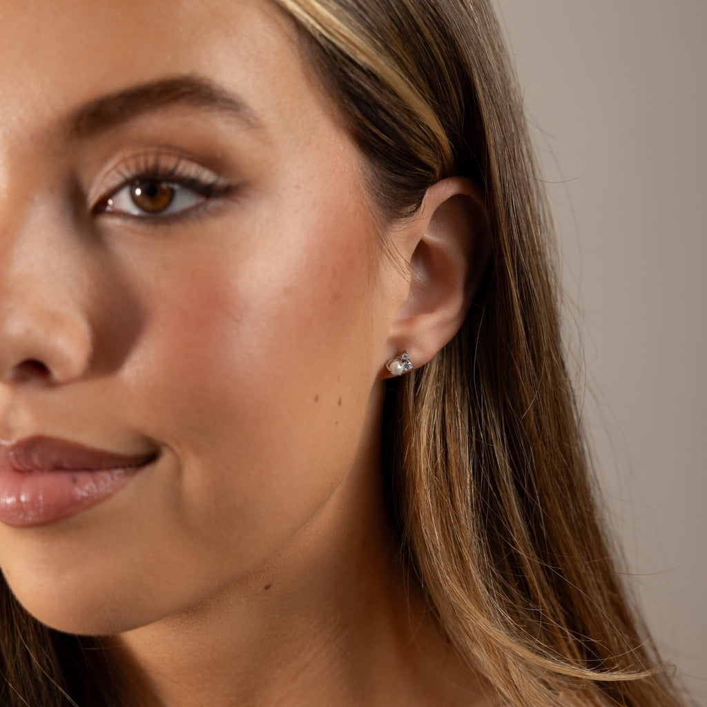 Close-up of a woman with long hair wearing Pearl Diamond Cluster Studs in her left ear.