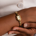 A person wearing the Azteca Link Timepiece, featuring a minimalist champagne dial and rectangular case, paired with a white button-up shirt.