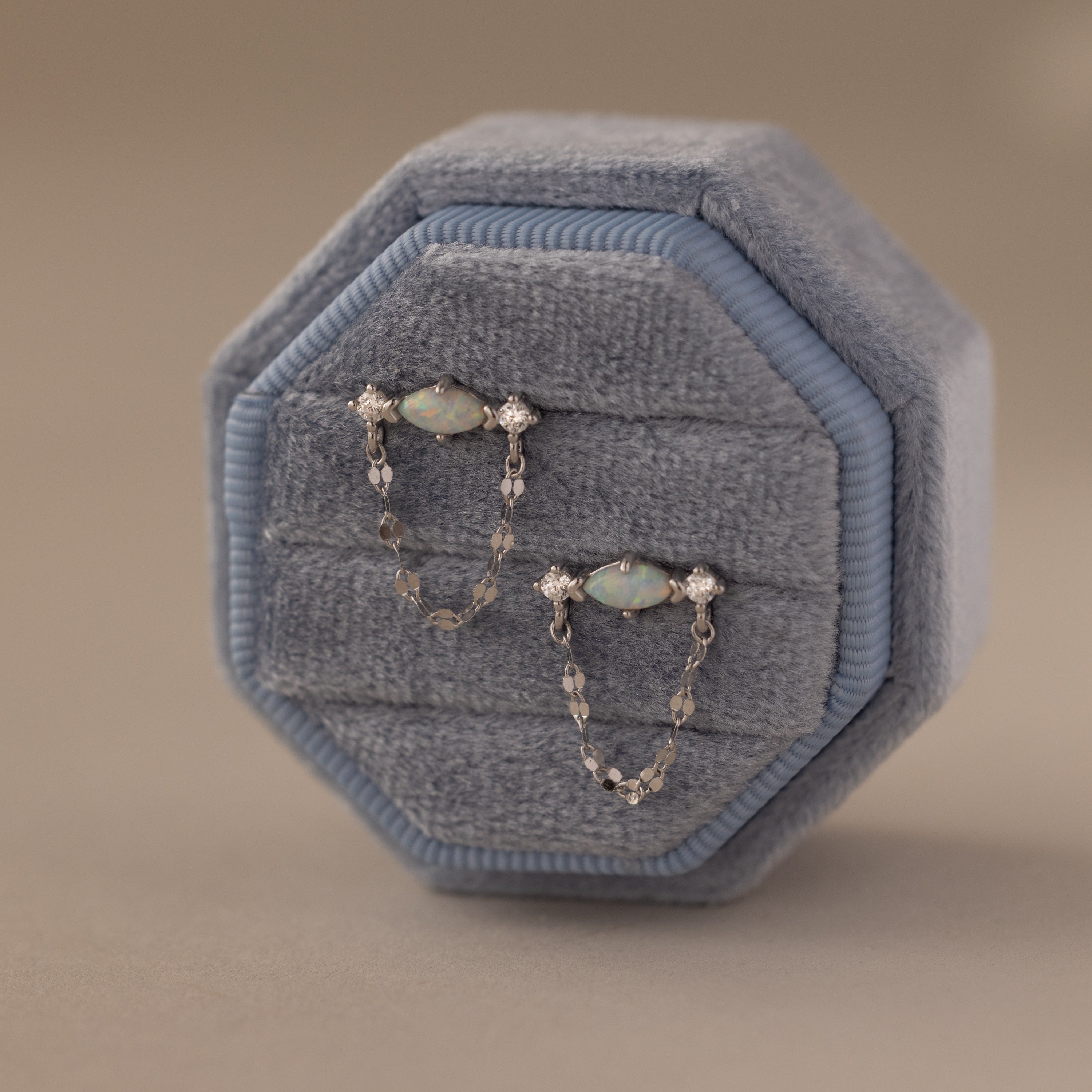 Flatlay of our Opal & Diamond Chain Studs in a Blue Velvet Jewelry Box