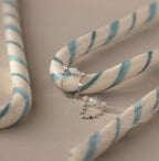 Flatlay of our Opal & Diamond Chain Studs against white and blue striped candy canes