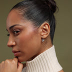 Model wearing our Pave Bow Charm Hoops against a neutral background