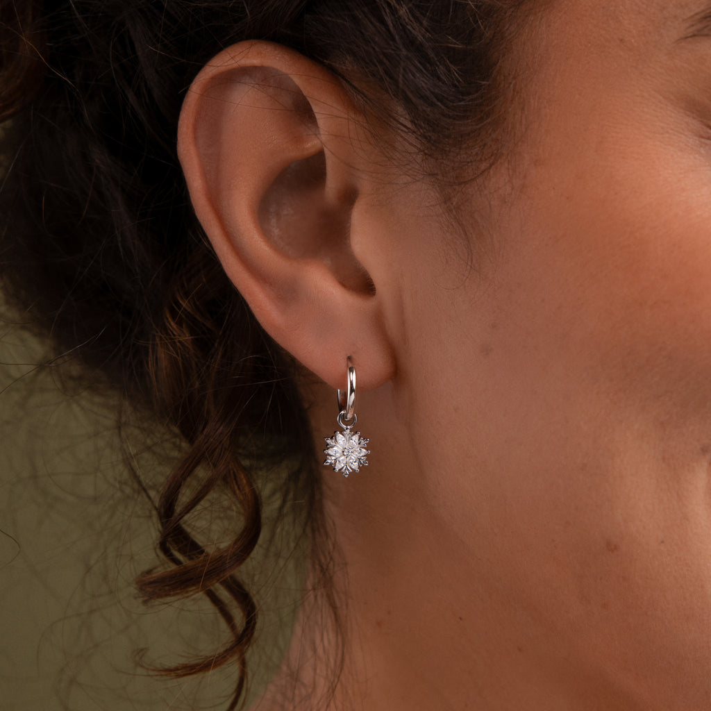 Close-up of aa model wearing our Diamond Poinsettia Hoops in Silver