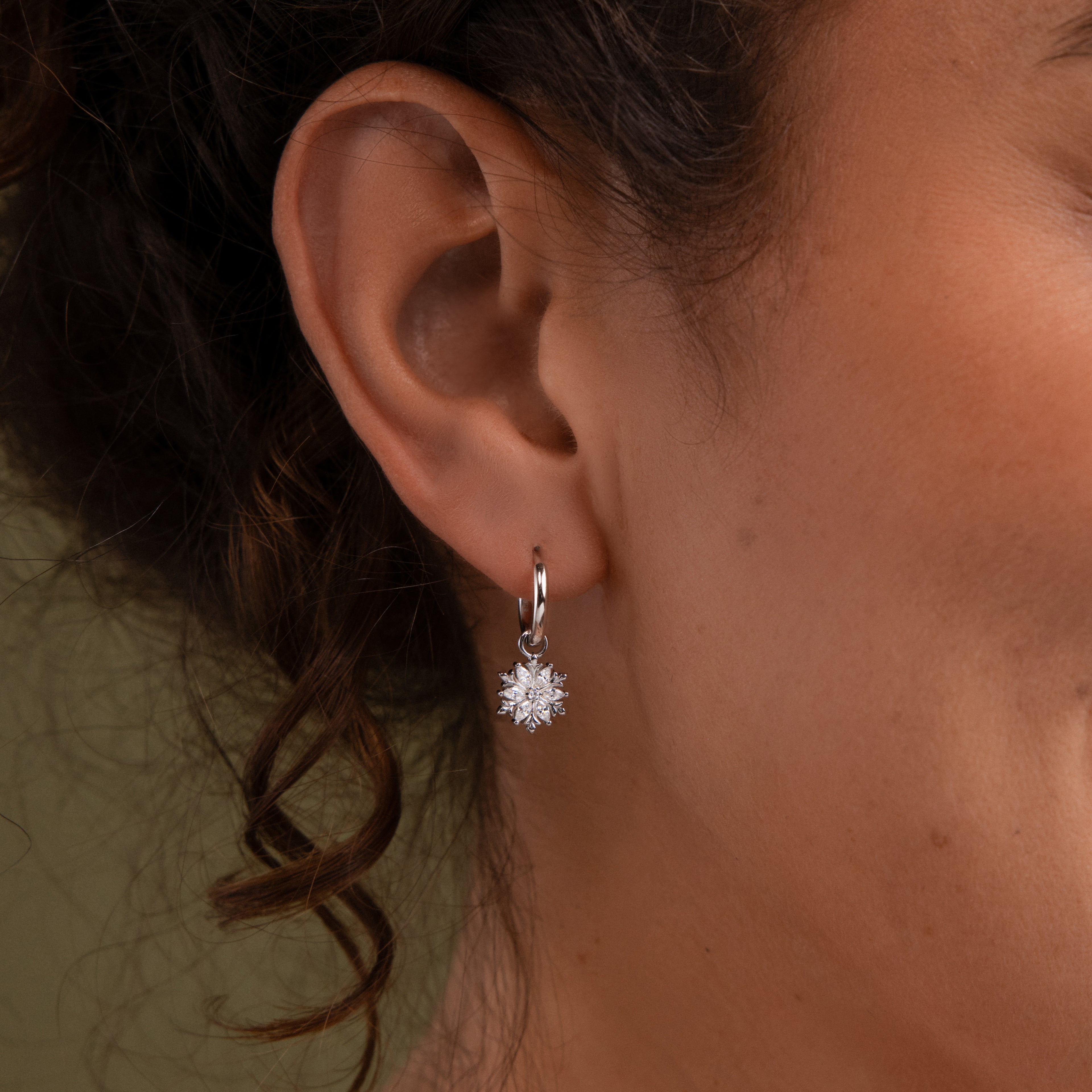 Close-up of aa model wearing our Diamond Poinsettia Hoops in Silver