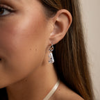 Close-up of a woman's ear wearing Starry Baroque Pearl Charm Hoops in White Gold, featuring delicate, bear-shaped Baroque pearls.