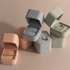 A Green Suede Ring Box in a soft pastel shade, showcasing a gold ring with a gemstone or diamond in an elegant minimalist style.