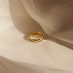 The Half Round Fingerprint Ring, engraved with "I love you!!", rests on soft cream fabric—this personalized piece of jewelry is uniquely crafted for you.