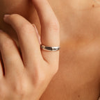 A hand wears a silver Half Round Fingerprint Ring engraved with "til death do us..." near their face, highlighting unique personalized jewelry.