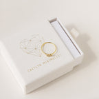 The Fingerprint Heart Ring sits on a white Caitlyn Minimalist box, showcasing its unique geometric heart—an ideal custom jewelry piece for anyone seeking a personal touch.