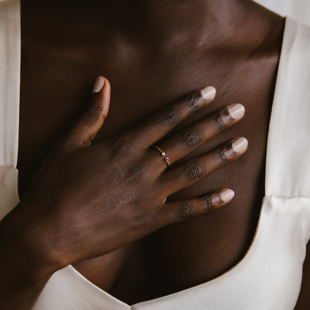 A close-up of a hand adorned with the Tiny Dual Birthstone Ring.