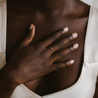 A close-up of a hand adorned with the Tiny Dual Birthstone Ring.
