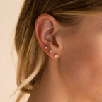 Close-up of a woman’s ear with three Booker Diamond Studs in a row—elegant, lightweight earrings perfect for everyday wear.