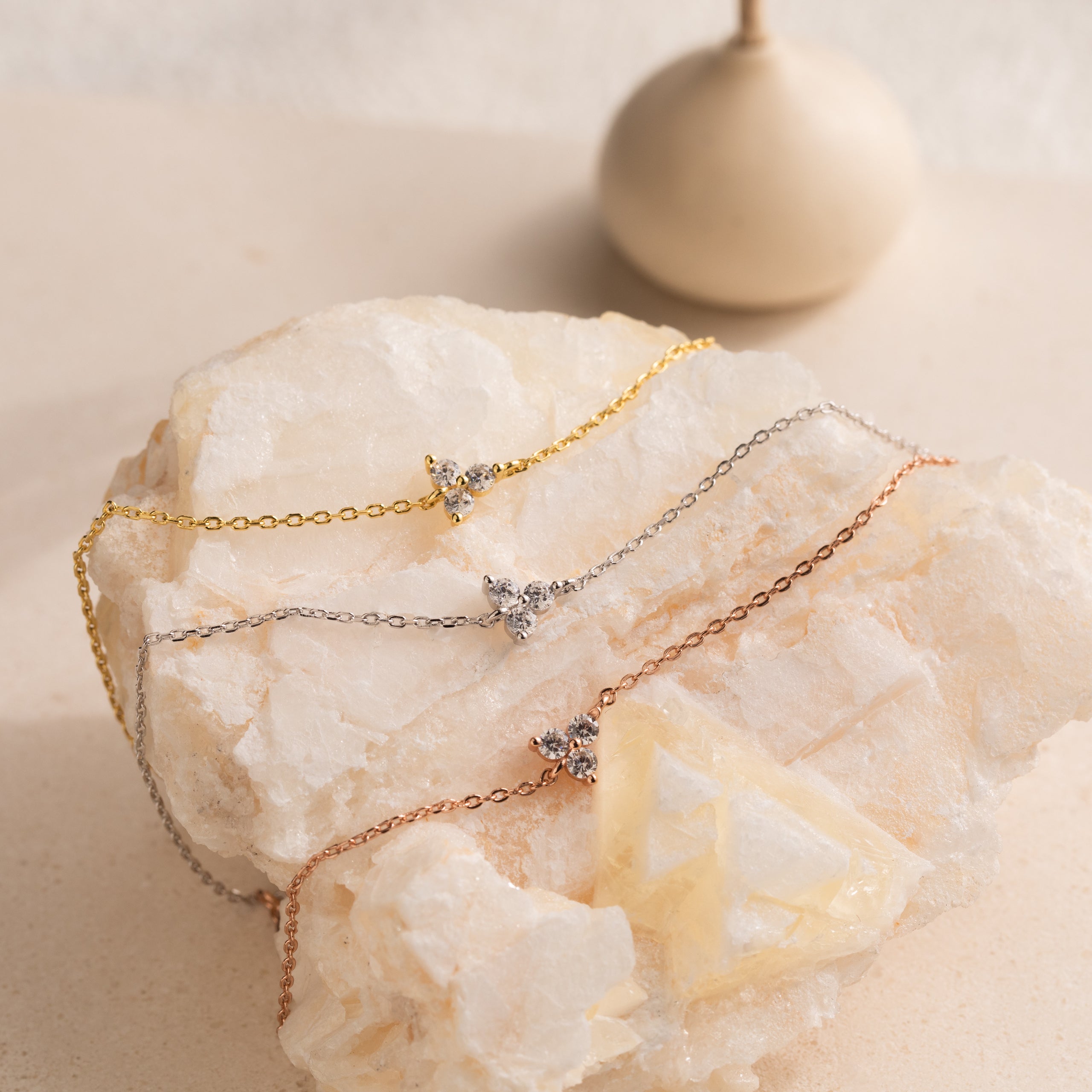 The Lily Diamond Bracelet features a delicate chain in gold, silver, or rose gold, each adorned with a sparkling diamond accent to beautifully elevate your evening look.