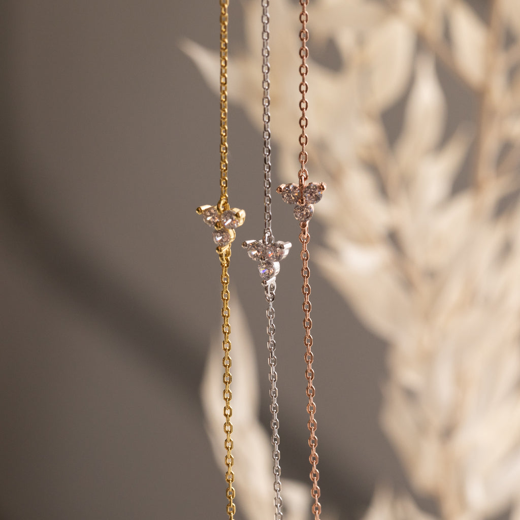 The Lily Diamond Bracelet features a delicate chain in gold, silver, or rose gold with a small floral pendant and subtle diamonds—perfect for adding elegance to your evening attire.