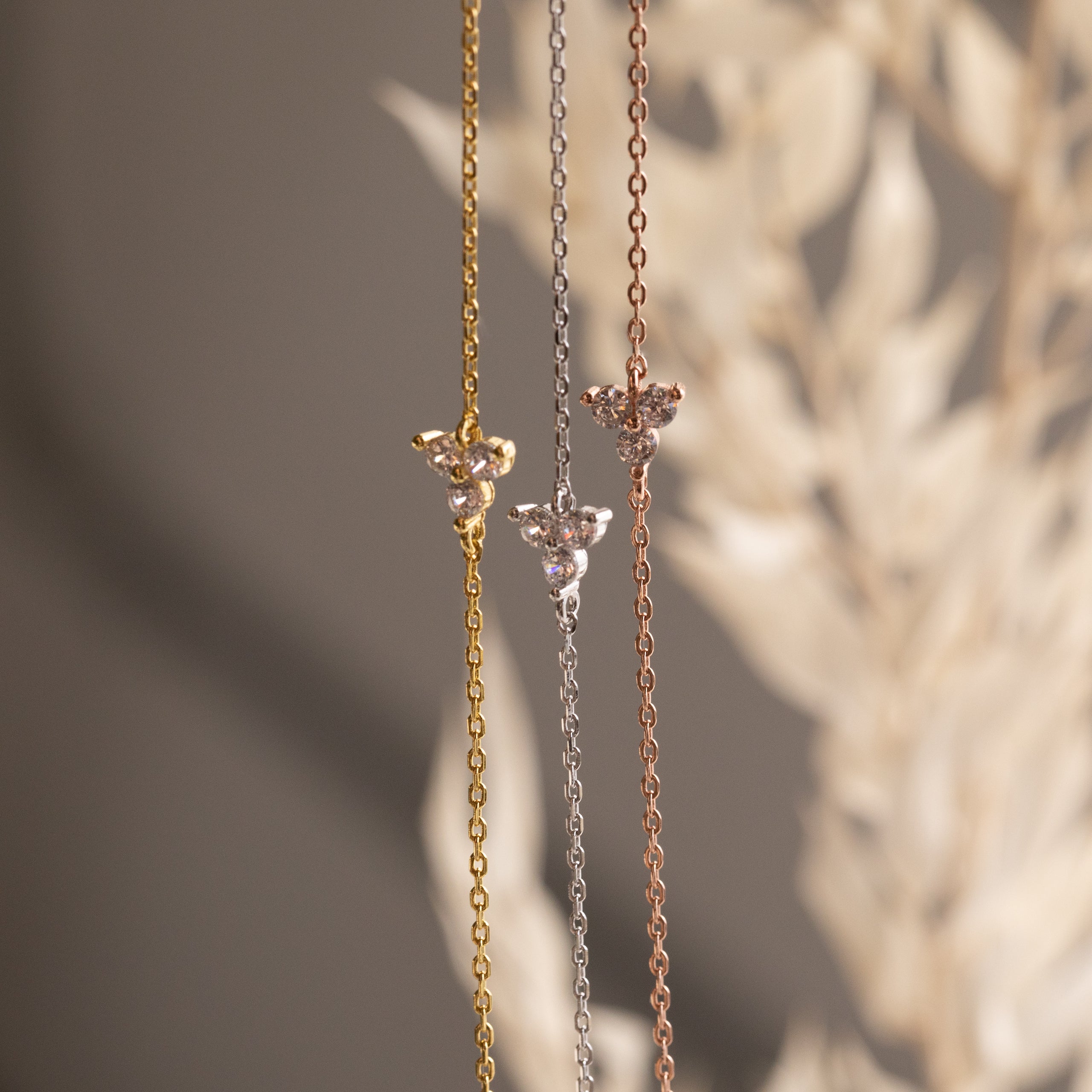 The Lily Diamond Bracelet features a delicate chain in gold, silver, or rose gold with a small floral pendant and subtle diamonds—perfect for adding elegance to your evening attire.