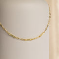 The Mini Name Bar Necklace showcases a gold chain with three custom name tags—Piper, Adam, and Charlotte—set against a neutral background.
