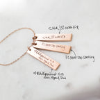 Three Vertical Handwriting Bar Necklaces engraved with personalized messages and names, highlighting custom jewelry on a white surface.