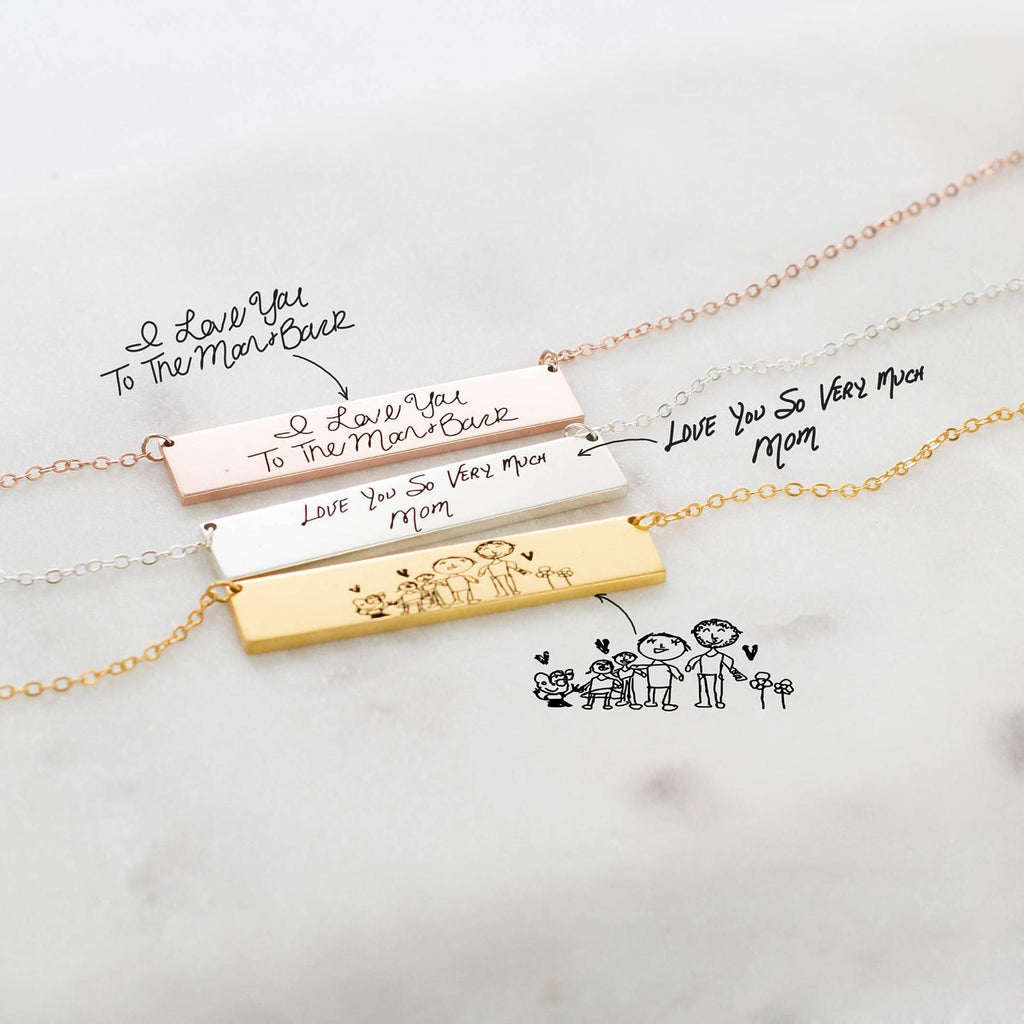 The Handwriting Bar Necklace in Rose Gold, personalized with "I love you" messages and family drawings, makes a heartfelt gift.