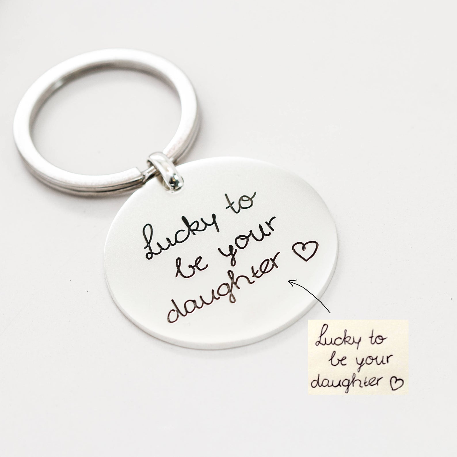 The Handwriting Circle Keychain, engraved with your handwritten message "Lucky to be your daughter" and a heart, makes a thoughtful personalized gift she’ll cherish.